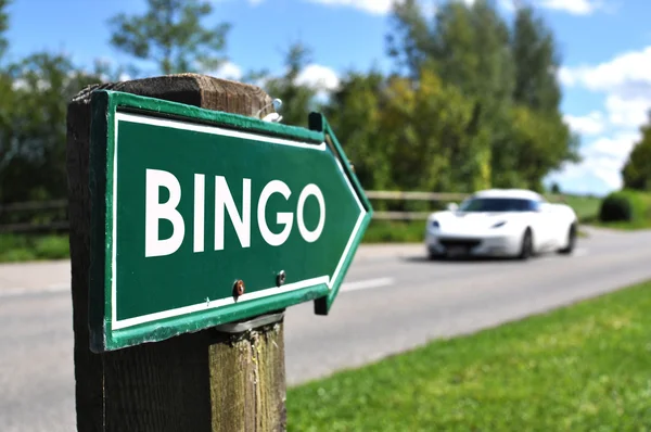 Знак BINGO против спортивного автомобиля на сельской дороге — стоковое фото
