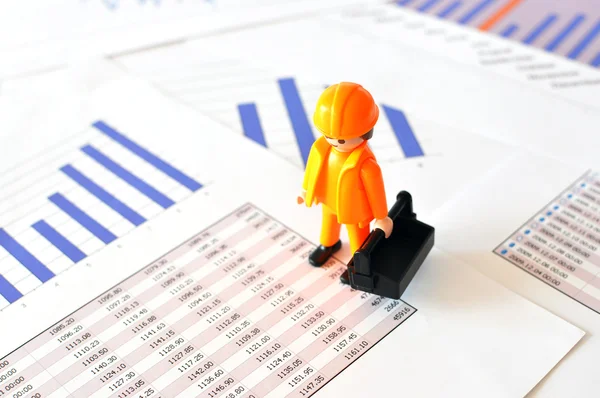 A little worker on a financial report — Stock Photo, Image