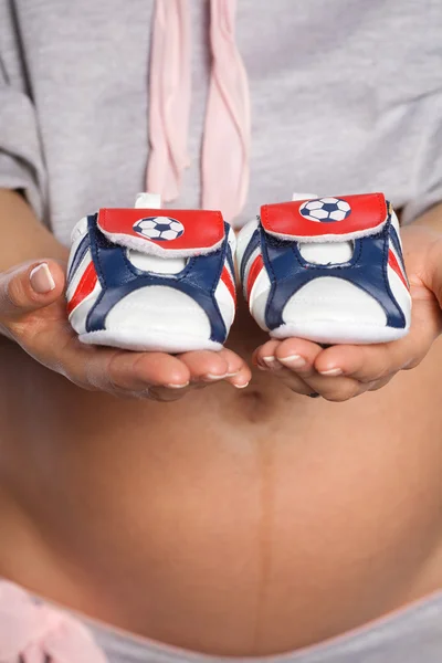 Donna incinta in possesso di scarpe bambino — Foto Stock