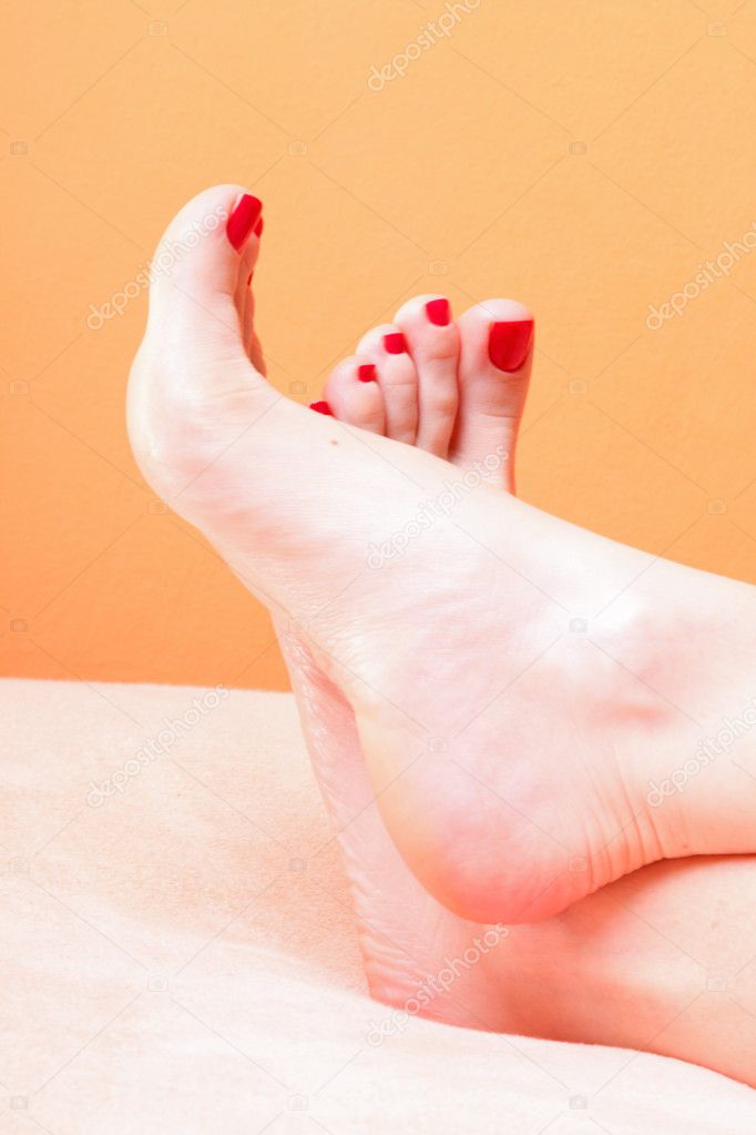 Woman feet with red toenails on towel