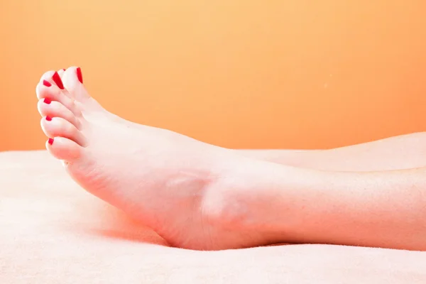 Nő lábát a vörös körmök, a törülközőt — Stock Fotó