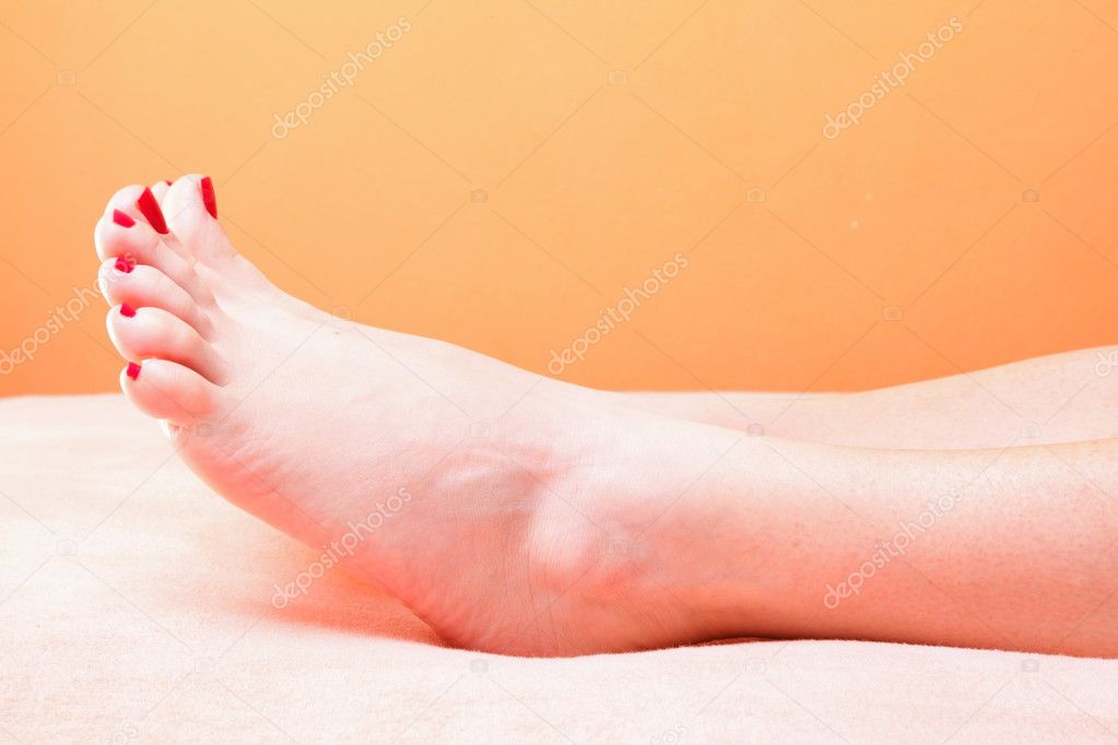 Woman feet with red toenails on towel