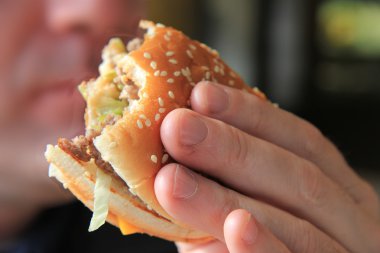 Man enjoying his hamburger clipart