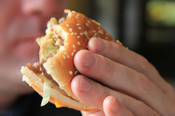 Man enjoying his hamburger — Stock Photo, Image