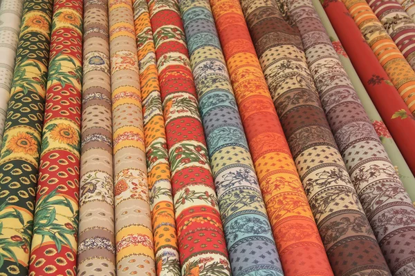 Rolos de têxteis provençal em uma banca de mercado — Fotografia de Stock