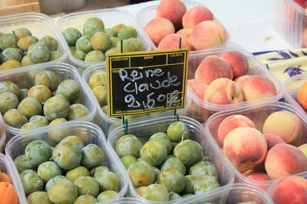 Prunes et pêches sur un marché français — Photo