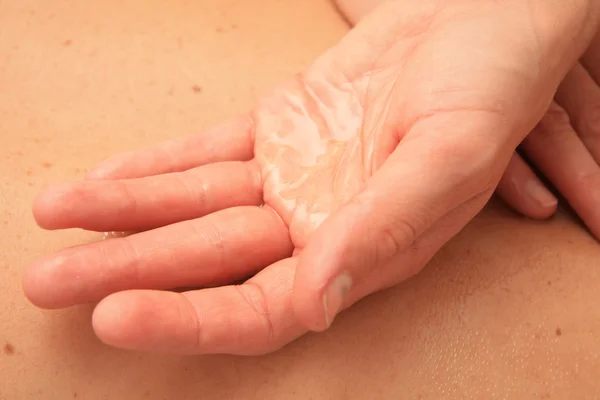Mano femminile con olio da massaggio — Foto Stock