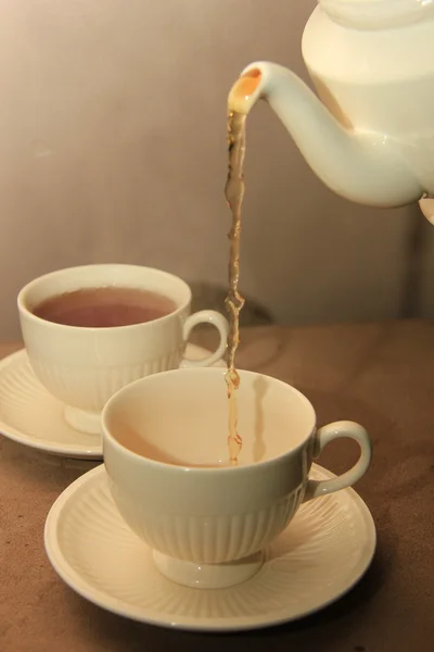 Hälla te i en klassisk vit vattenglas — Stockfoto