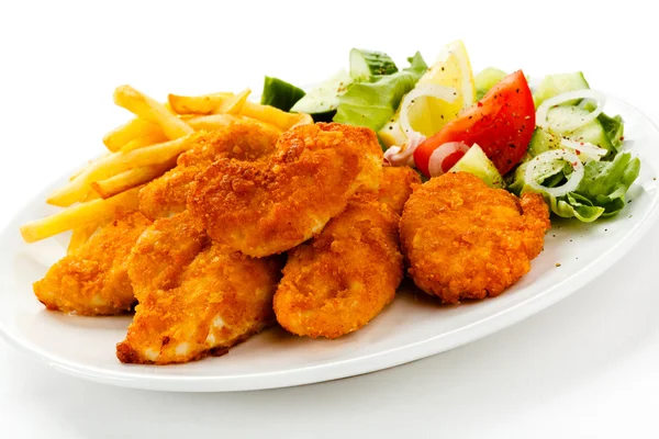 Fried chicken nuggets, French fries and vegetables — Stock Photo, Image