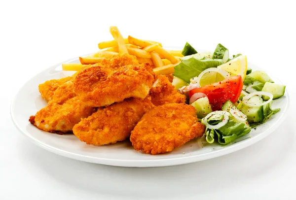 Fried chicken nuggets, French fries and vegetables — Stock Photo, Image