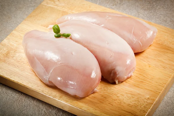Surowe piersi z kurczaka na deski do krojenia — Zdjęcie stockowe