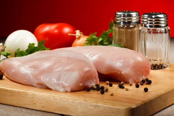 Peitos de frango crus na tábua de corte — Fotografia de Stock