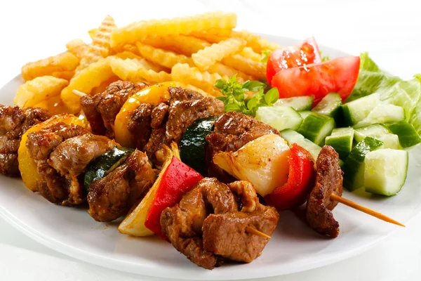 Смажене м'ясо, картопля фрі та овочі — стокове фото
