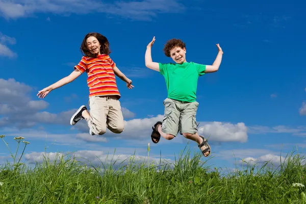 Fille et garçon courir, sauter en plein air — Photo