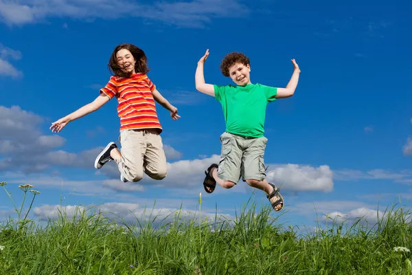 Chica y niño corriendo, saltando al aire libre —  Fotos de Stock