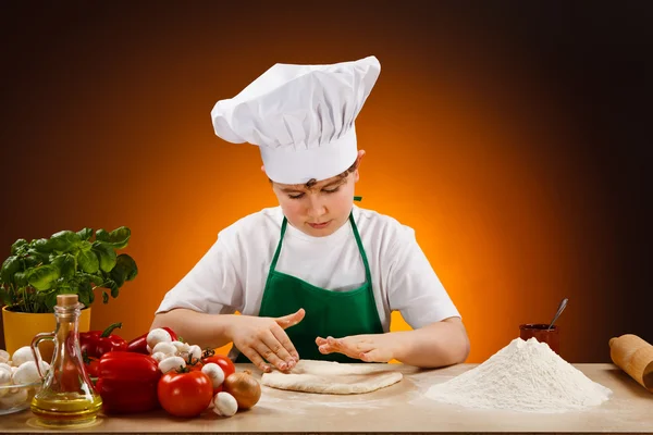 Мальчик делает тесто для пиццы — стоковое фото