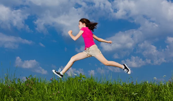 Chica saltando, corriendo contra el cielo azul — Foto de Stock