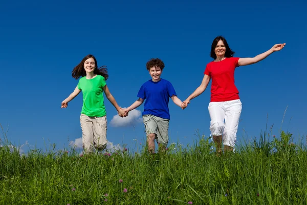 Активная семья - бег матери и детей, прыжки на свежем воздухе — стоковое фото