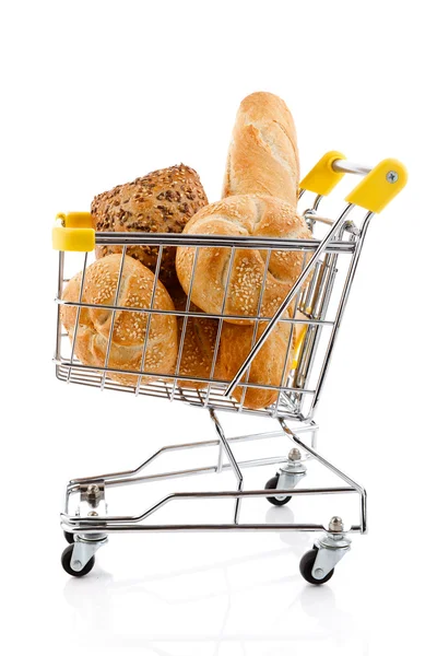 Nákupní vozík plný chleba a rohlíky na bílém pozadí — Stock fotografie