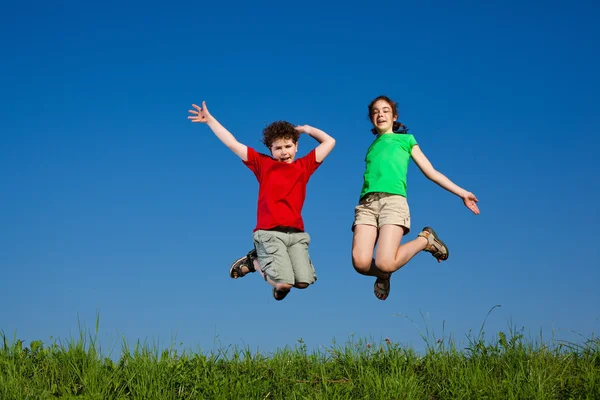 Дівчинка і хлопчик біжить, стрибає на відкритому повітрі — стокове фото