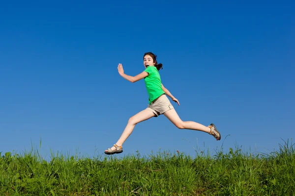 Flicka hoppa, kör mot blå himmel — Stockfoto