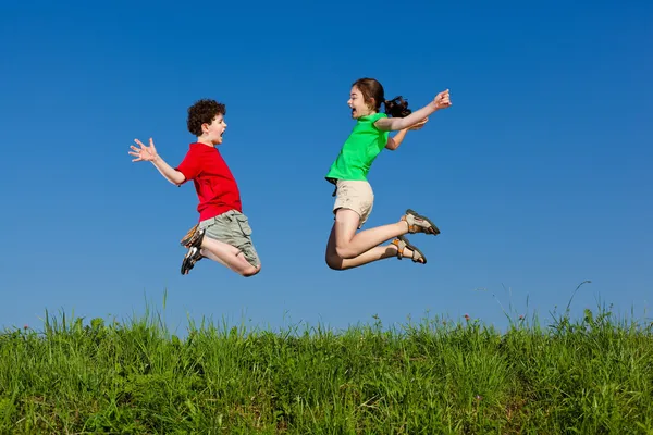 Flickan och pojken springa, hoppa utomhus — Stockfoto