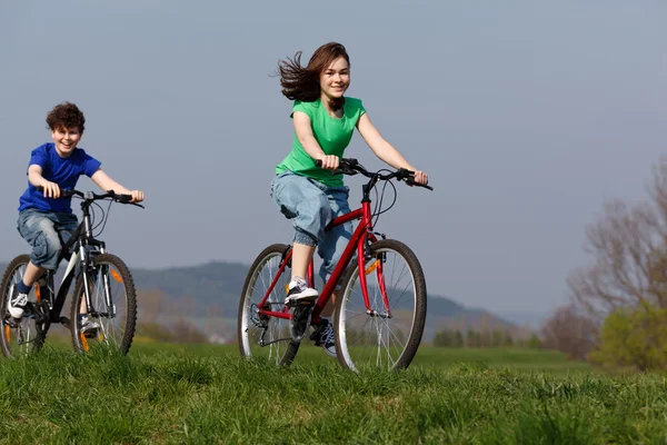 女孩和男孩骑自行车 — 图库照片