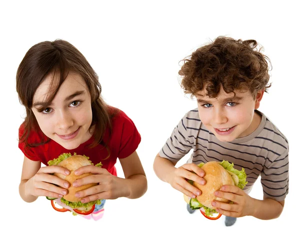 Crianças comendo sanduíche grande isolado no fundo branco — Fotografia de Stock