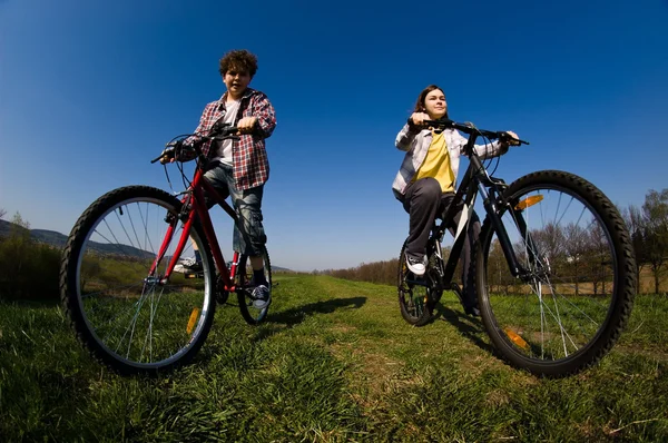 Ragazza e ragazzo in sella biciclette — Foto Stock