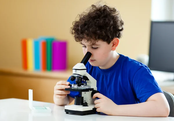 Menino examinando preparação ao microscópio — Fotografia de Stock