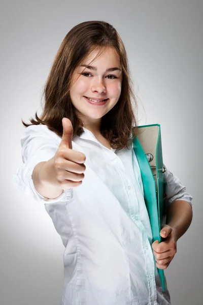 Girl holding book showing OK sign on gray background — Stock Photo, Image