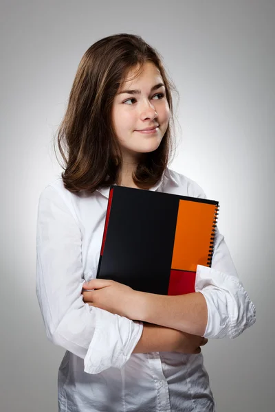 Chica sosteniendo libro sobre fondo gris —  Fotos de Stock