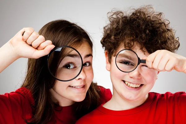 Ragazza e ragazzo in possesso di lente d'ingrandimento — Foto Stock