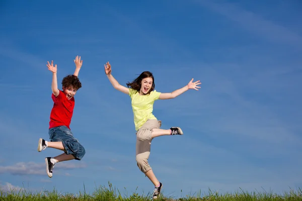 Chica y niño corriendo, saltando al aire libre —  Fotos de Stock
