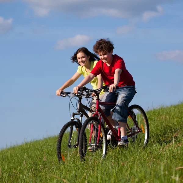 Chica y niño montando bicicletas — Foto de Stock