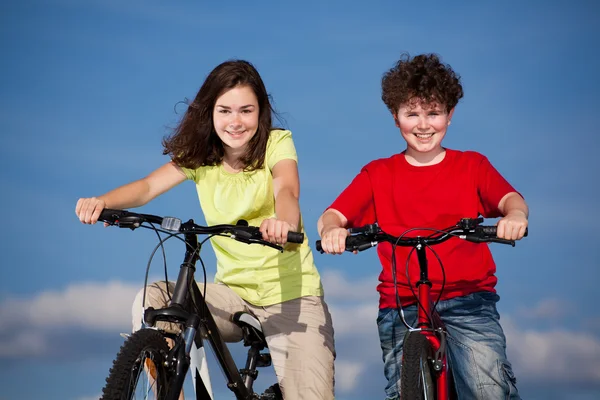 Chica y niño montando bicicletas — Foto de Stock