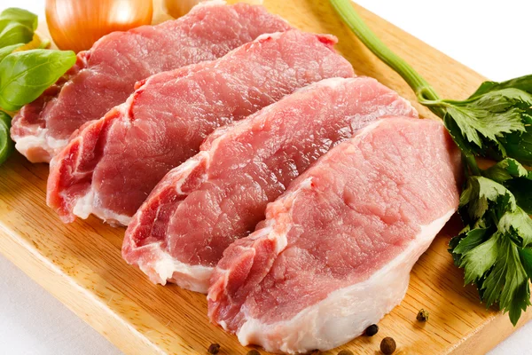 Kesme tahtasında çiğ domuz eti ve sebze. — Stok fotoğraf
