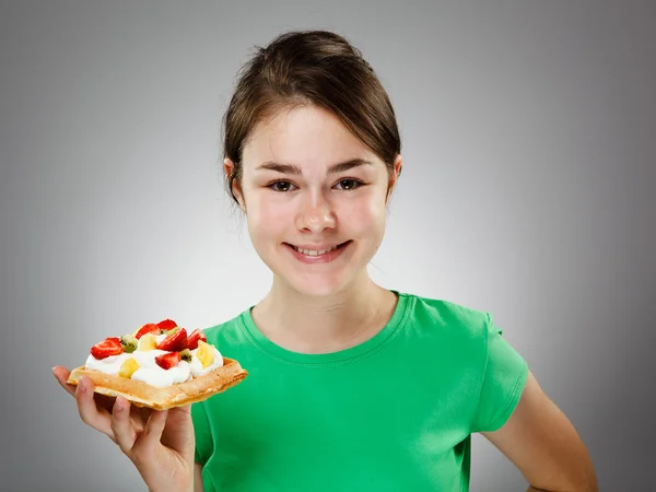 Mädchen isst Kuchen mit Sahne und Früchten — Stockfoto