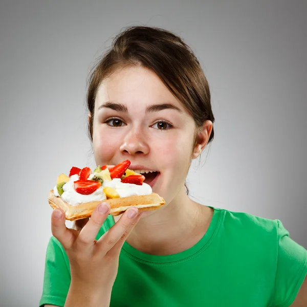 Ragazza mangiare torta con panna e frutta — Foto Stock