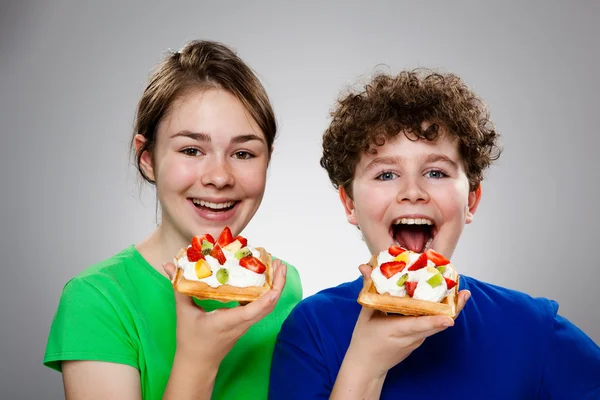 Kek krem ve meyve yeme çocuklar — Stok fotoğraf