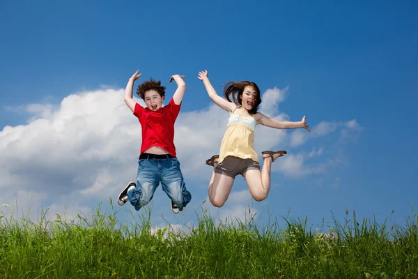 Kız ve oğlan koşma, atlama açık — Stok fotoğraf