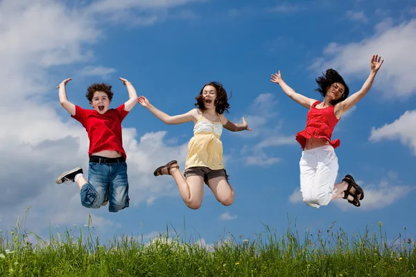 Активная семья - мать и дети прыгают на открытом воздухе — стоковое фото