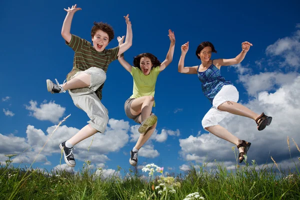 Actieve familie - moeder en kinderen buiten springen — Stockfoto