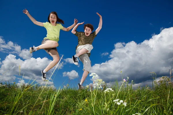 女の子と男の子のランニング、ジャンプ屋外 — ストック写真
