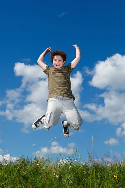 Niño saltando, corriendo contra el cielo azul —  Fotos de Stock