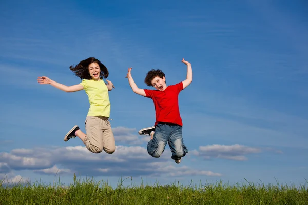 Menina e menino correndo, pulando ao ar livre — Fotografia de Stock
