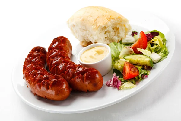 Grilled sausages, bun and vegetables — Stock Photo, Image