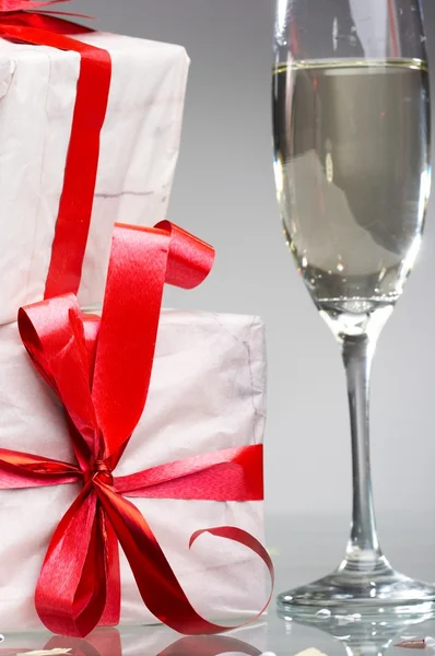 シャンパン、赤テープと弓が付いているギフトのメガネ — ストック写真