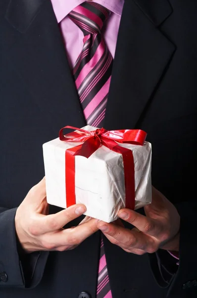 Muž dovolené a nabízí dárek na ruce — Stock fotografie