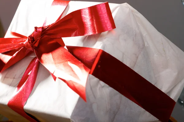 Kırmızı şeritler ve yay ile hediye — Stok fotoğraf